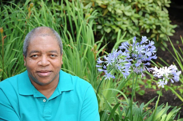 屋外の花畑でアフリカ系アメリカ人男性のシニア表現 — ストック写真