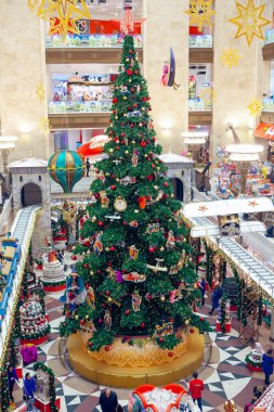 MOSCOW, RUSSIA - 7 Aralık 2016: Orta Çocuk Mağazası 'ndaki bir alışveriş merkezinde süslemeli Noel ağacı. Arka planda yürüyen insanlar. Yeni yıl, kış tatilleri, hediyeler....