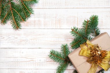 Noel arkaplanı - köknar dalları ve hediye kutusu beyaz ahşap bir masada. Düz düzen, kopyalama alanı ile üst görünüm bileşimi sınırı.