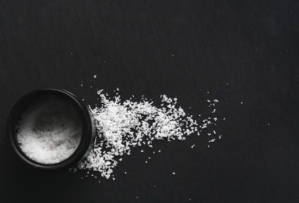 有機海の白い塩と黒いスレートの石の背景の瓶 天然健康食品を調理するコンセプト テキストのための部屋 — ストック写真