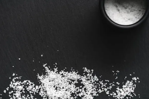 有機海の白い塩と黒いスレートの石の背景の瓶 天然健康食品を調理するコンセプト テキストのための部屋 — ストック写真