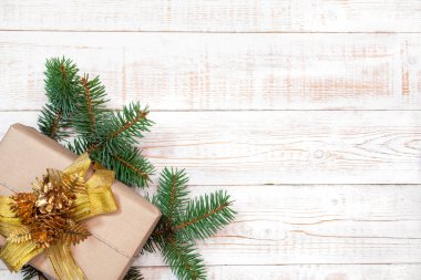 Noel arkaplanı - köknar dalları ve hediye kutusu beyaz ahşap bir masada. Düz düzen, kopyalama alanı ile üst görünüm bileşimi sınırı.