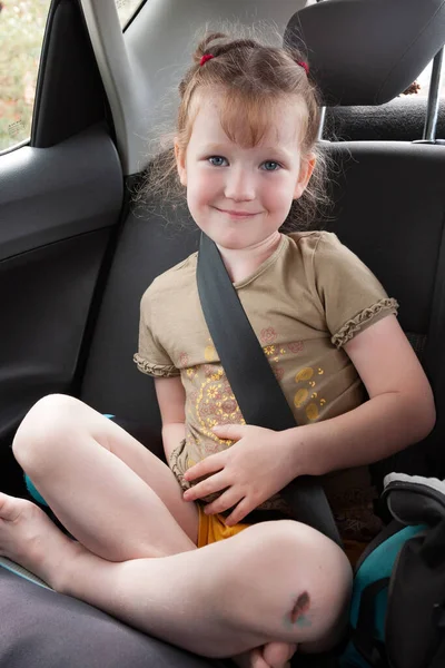 小女孩坐在汽车后座上 系好安全带 — 图库照片