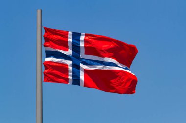 Norveç Bayrağı Mavi gökyüzüne karşı Rüzgarda Dalgalanıyor.