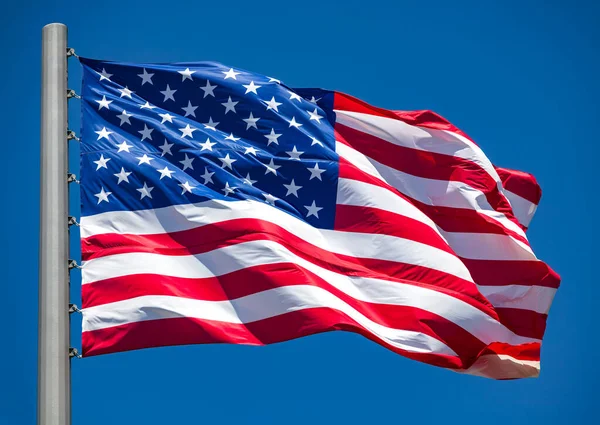 Mavi gökyüzünde dalgalanan Amerikan bayrağı