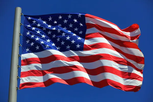 Bandiera Americana Sventola Nel Vento Contro Cielo Blu Immagini Stock Royalty Free