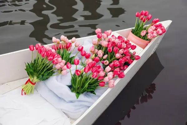 水面上的白船上有一束粉红色的郁金香 免版税图库照片