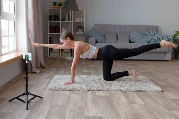 Siyah Taytlı Beyaz Tişörtlü Bir Kadın Evde Halının Üzerinde Yoga Telifsiz Stok Imajlar