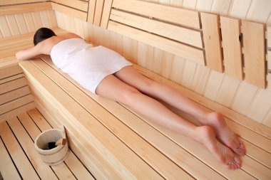 Genç bir kadın saunada dinleniyor. Spa tedavisi kavramı
