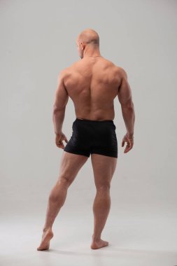 Sırtını gösteren kaslı erkek model.