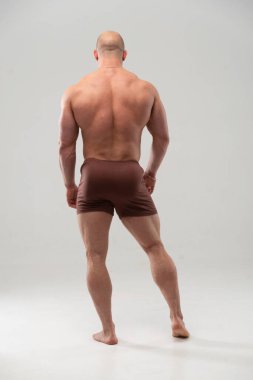 Sırtını gösteren kaslı erkek model.