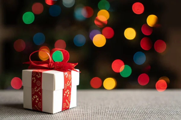 Weiße Geschenkschachtel Mit Rotem Band Vor Dem Hintergrund Des Weihnachtsbaums — Stockfoto