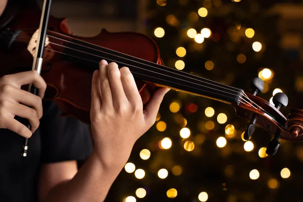 ティーン女の子パフォーマンスホリデーバイオリン曲で黒フォーマル摩耗上のクリスマス背景 — ストック写真