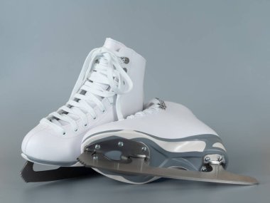 Pair of white figure ice skates shoes on blank gray background
