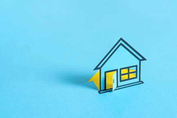 Blue colored papered house on blank blue background