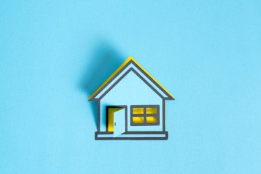 Blue colored papered house on blank blue background