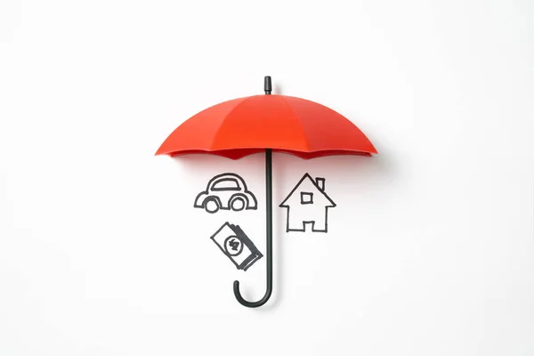 在红色保护伞下的货币图标保险保护的概念 免版税图库照片