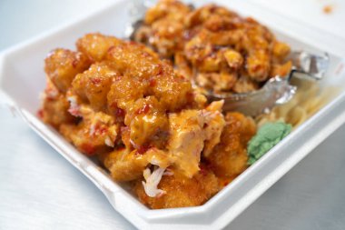 Baharatlı mayonez ve teriyaki soslu kavrulmuş karides suşi rulosu.