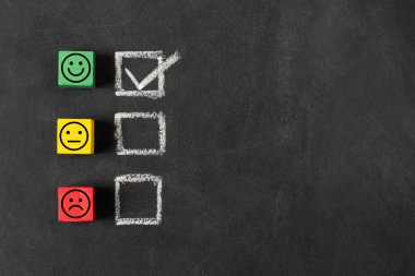 Farklı ifadelere sahip üç yüz emojisi, pozitif, nötr ve negatif tahta bloklar, hayatta olumlu ve mutlu olma konsepti veya müşteri memnuniyeti anketi