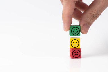 Farklı ifadelere sahip üç yüz emojisi, pozitif, nötr ve negatif tahta bloklar, hayatta olumlu ve mutlu olma konsepti veya müşteri memnuniyeti anketi