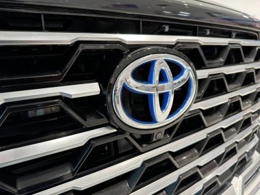 Novi, Michigan, ABD - 9 Temmuz 2024: Mavi renkli Toyota logosu bir hibrit modeli gösteriyor.