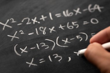 Matematiksel işlemler ve matematik formülleri tahtaya tebeşirle yazılmış.