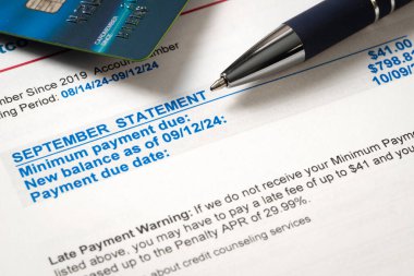 Yeni bakiye borcunu gösteren kredi kartı ekstresi, asgari ödeme süresi ve ödeme tarihi, kalem ve kredi kartıyla birlikte