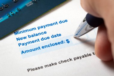 Yeni bakiye borcunu gösteren kredi kartı ekstresi, asgari ödeme süresi ve ödeme tarihi, kalem ve kredi kartıyla birlikte