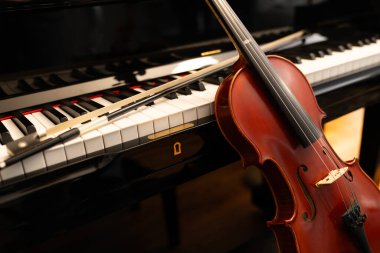 Müzik konsepti veya orkestra konseri performansı için kopyalama alanı olan piyano klavyesi arka planında keman.