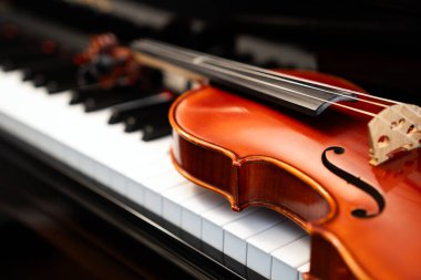 Müzik konsepti veya orkestra konseri performansı için kopyalama alanı olan piyano klavyesi arka planında keman.
