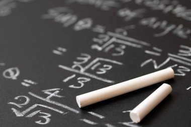 Matematiksel işlemler ve trigonometri matematik formülü tahtaya tebeşirle yazılmış.
