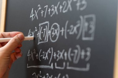 Matematiksel işlemler ve matematik formülü tahtaya tebeşirle yazılmış.