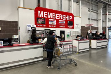 Ticaret Kasabası, Michigan, ABD - 29 Mar 2025: Müşterilere çalışanların yardım ettiği bir Costco üyelik tezgahı, üyelik seçeneklerini gösteren büyük bir tabela.