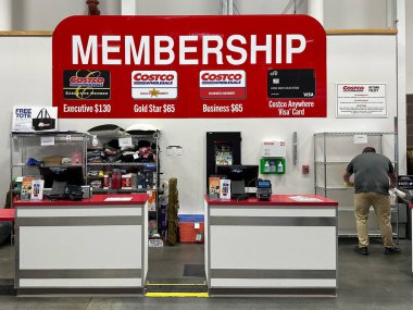 Ticaret Kasabası, Michigan, ABD - 29 Mar 2025: Müşterilere çalışanların yardım ettiği bir Costco üyelik tezgahı, üyelik seçeneklerini gösteren büyük bir tabela.