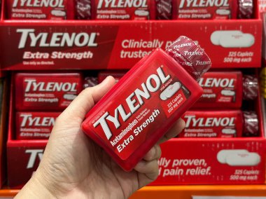 Novi, Michigan, ABD - Bölüm 28, 2025: Bir Costco eczane bölümünün raflarında düzgünce yerleştirilmiş bir şişe Tylenol ilave ağrı kesici ve ateş düşürücü ile el ele tutuşun