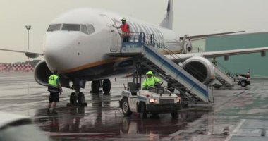Budapeşte, Macaristan - 2021 dolaylarında: Ryanair uçakları havaalanına varıyor, zemin tutuşu çıkışlara merdiven yerleştirerek başlıyor, polan kapısı açılıyor
