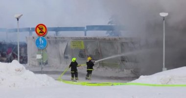 Saariselka, Finlandiya - 2022 civarı: Finlandiya 'daki alışveriş merkezi Kuukkeli' nin yakılması. İtfaiyeciler alevleri durdurmaya çalışıyor.