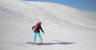 Alplerde snowboard yapan bir kadın, kamera önünde hareketli bir çekim.
