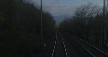 Tren yolculuğu bakış açısı son vagonun arkasından, tren yolculuğu, alacakaranlık manzarası.