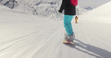 Alplerde snowboard yapan bir kadın, hareket takip eden çekimler, geniş açılı ve geniş açılı kamera, alçak açılı.