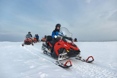 Finlandiya 'da kar motosikletine binen Arktik Daire' nin üstündeki kadın binici