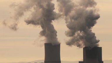 Power plant cooling towers emiting steam. Can be nuclear or fossil fuel fired power station