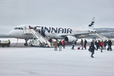 Ivalo, Finlandiya - 2022 dolaylarında: Helsinki 'den kalkan Finnair uçağı, çıkış kapılarına bağlı merdivenlerden inen yolcularla Ivalo havaalanına inmiştir. Kuzey havalimanı kutup dairesinin ötesinde.
