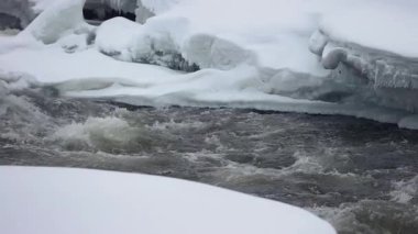 Kuzey kışında hızlı akan nehir, çoğunlukla donmuş buz blokları, 120 fps 'den yavaş çekim.