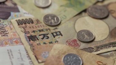 Currencies from around the world, collage of banknotes and coins, spinning slow