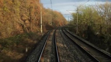 Train journey point of view from the back of the last wagon, autumn leaves moving in the air turbulance