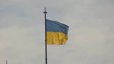 Bulutlu gökyüzünde dalgalanan Ukrayna bayrağı