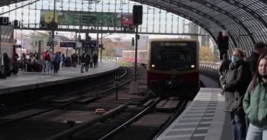 Berlin, Germany - Circa 2022: Arriving train to the main, central train station of Berlin Hauptbahnhof, passangers waiting on the platform. Citys public transport system