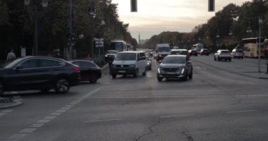 Berlin, Germany - Circa 2022: Cars passing an intersection on a main avenue, driving in twilight traffic in the city of Berlin