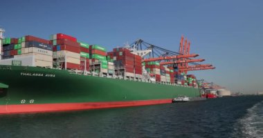 Rotterdam, Hollanda - 2019 dolaylarında, Rotterdam Limanı 'nın Euromax konteyner terminalindeki büyük bir kargo gemisine yüklenen konteynırlar, sanayi limanlarındaki gantry vinçleri,